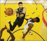  ?? Jed Jacobsohn / Associated Press ?? Celtics forward Jayson Tatum, left, shoots against the Warriors’ Andrew Wiggins in Game 5 on Monday.