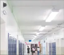  ?? AP PHOTO ?? Students walk down a hallway July 10 at Lockport High School in Lockport, N.Y. On the upper left a camera with facial recognitio­n capabiliti­es hangs on the wall waiting for its installati­on to be completed.