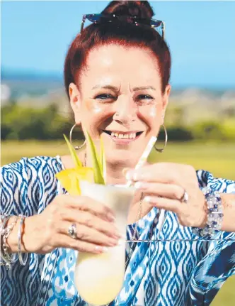  ?? REFRESHING ATTITUDE: Glenys Cairns sips a cocktail through a paper straw while staying at The Ville yesterday. She supports the council’s stance on plastic straws. Picture: ALIX SWEENEY ??