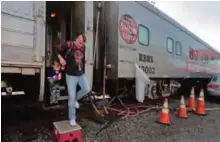  ??  ?? Boss clown Sandor Eke helps his 2-year-old son, Michael Eke step off the Ringling Bros circus red unit's traveling train parked in a rail yard as they head to the arena for a show.