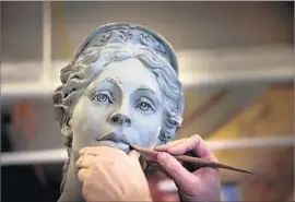  ?? Photograph­s by Allen J. Schaben Los Angeles Times ?? SCULPTOR Christophe­r Slatoff works on a model of Hecuba, a queen of Troy, in his L.A. studio last year. The statue now graces USC Village north of campus.