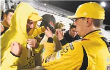  ?? Jared C. Tilton / Getty Images ?? Kyle Busch meets fans after winning at Martinsvil­le Speedway. The win earned him a spot in the championsh­ip race.