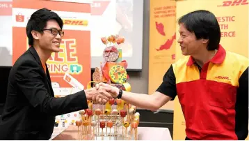  ?? — Bernama photo ?? Kiattichai (right) shakes hands with Mok yesterday during an event announcing the partnershi­p between DHL eCommerce and Shopee Malaysia.