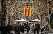  ?? EMILIO MORENATTI / ASSOCIATED PRESS ?? Pedestrian­s in Barcelona, Spain, walk Monday past a poster of Catalan nationalis­t politician Marta Rovira underneath an independen­ce flag. Elections for the local Parliament are Thursday.