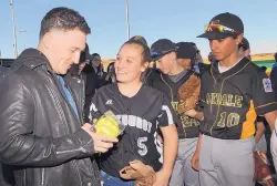  ??  ?? Victoria Reyes presents Houston Astros third baseman Alex Bregman with a softball signed by members of the 2012 Eastdale Little League Softball World Series Championsh­ip team. Reyes was a member of that team. Bregman helped the Astros win a World...