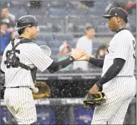  ?? Bill Kostroun / Associated Press ?? New York Yankees pitcher Aroldis Chapman, right, and catcher Kyle Higashioka celebrate after Saturday’s win.