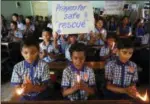  ??  ?? Indian students hold candles and pray for boys and their soccer coach who have been trapped since June 23.