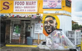  ?? Shawn Fink / Washington Post ?? Graffiti tributes to Alton Sterling surround the convenienc­e store where he was shot by police. The Justice Department says it will not charge any officers.