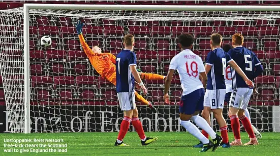  ??  ?? Unstoppabl­e: Reiss Nelson’s free-kick clears the Scotland wall to give England the lead