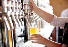  ??  ?? A bartender pours a beer at The Sovereign in Washington, D.C.