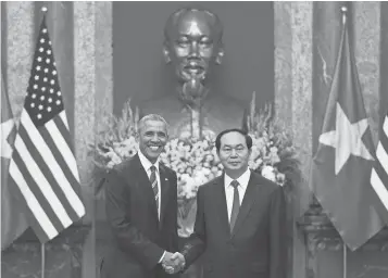  ?? JIM WATSON, AFP/ GETTY IMAGES ?? President Obama shakes hands with Vietnamese President Tran Dai Quang during a visit to Hanoi on Monday. Obama lifted the arms embargo on Vietnam during his visit.