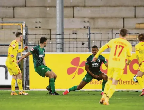  ?? Foto: dpa ?? Freiburgs Roland Sallai (links) kommt zum Abschluss, Rani Khedira und Felix Uduokhai können das 0:1 nicht mehr verhindern. Der Fehler ist vorher auf der rechten Abwehr‰ seite passiert, als kein Augsburger Christian Günter stoppen konnte.