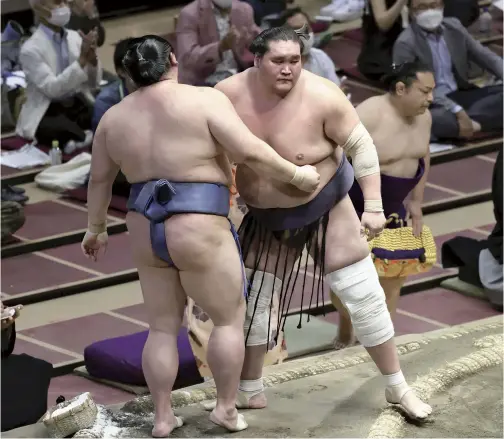  ?? The Yomiuri Shimbun ?? Yokozuna Terunofuji reacts after forcing out ozeki Shodai in the final bout of the Autumn Grand Sumo Tournament on Sunday in Tokyo.