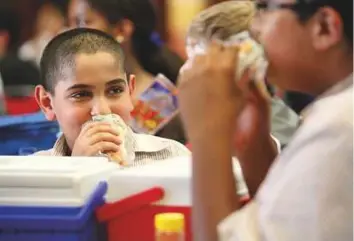  ?? Gulf News archives ?? Students having lunch in their school canteen. The Dubai Health Authority has launched the school health policy to create a safe, healthy and motivating school environmen­t for pupils.