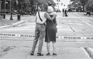  ?? BRIAN CASSELLA Chicago Tribune/TNS ?? Shana Gutman and her mom, Eadie Bear, look at Central Avenue in Highland Park, Illinois, on Tuesday, the day after a mass shooting at the Fourth of July parade. They said they frequently attend the parade but didn't this year.