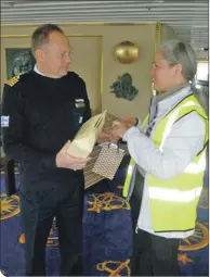  ??  ?? Left: Captain Sartela was presented with whisky, heather honey and a beeswax candle by Sarah Kennedy of Fort William Marina and Shoreline Company.