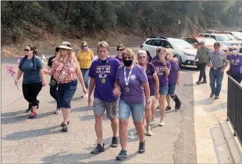  ?? Alex Maclean / Union Democrat ?? About 20 friends of Crystal Falls couple Sheri Malone (front right, holding sign) and Blair Godbout (front left) participat­e on Saturday in the Walk to End Alzheimer’s, which Godbout was diagnosed with eight years ago.