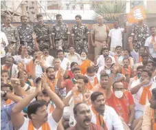  ?? — BY ARRANGEMEN­T ?? Police watch as BJP activists protest outside the house of Parkal TRS MLA Challa Dharma Reddy on Sunday.