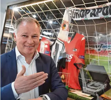  ??  ?? Trikots und Schal künden von der Europa Tour des FC Augsburg vor wenigen Jahren. Doch Geschäftsf­ührer Stefan Reuter warnt davor, dass auch immer noch der Abstieg in die zweite Liga möglich ist.