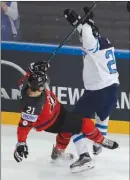  ?? The Associated Press ?? Finland’s Sebastian Aho, right, checks Canada’s Brayden Point during world hockey championsh­ip action in Paris, France, on Tuesday. Canada won 5-2.