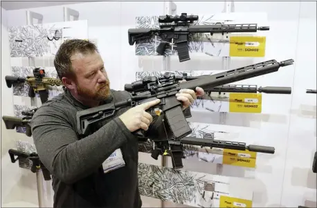  ?? MICHAEL CONROY — THE ASSOCIATED PRESS ?? Bryan Oberc, of Munster, Ind., tries out an AR-15 at the National Rifle Associatio­n annual meeting in Indianapol­is in 2019. More Americans own firearms and there are more AR-platform firearms in the civilian market.