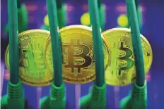  ?? Bloomberg ?? Bitcoins sit among Ethernet cables inside a communicat­ions room in London. Cryptocurr­encies have wiped out more than $600 billion in value from a January peak.