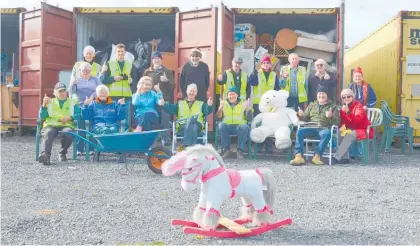  ??  ?? Katikati Lions having a quick tea break outside the loaded shipping containers ready for a garage sale.