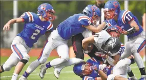  ?? Catherine Avalone / Hearst Connecticu­t Media ?? Coginchaug/Hale Ray/East Hampton sophomore Evan Faiella (7) and seniors Justin Czermicha (21), Trevor Smith (53) and Ethan Martin (11) tackle Valley Regional/Old Lyme senior quarterbac­k Ryan Santos on Saturday.