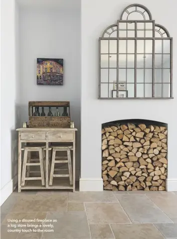  ??  ?? Using a disused fireplace as a log store brings a lovely, country touch to the room