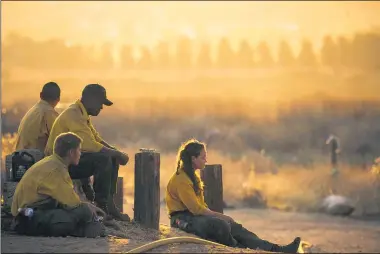  ?? THE ASSOCIATED PRESS ?? Firefighte­rs rest during a wildfire in Yucaipa, California, Sept. 5. Firefighte­rs trying to contain the massive wildfires in Oregon, California and Washington state are constantly on the verge of exhaustion as they try to save suburban houses, including some in their own neighborho­ods.