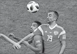  ?? DARKO BANDIC/AP PHOTO ?? Russia’s Alexander Samedov, right, tries to stop Saudi Arabia’s Salem Aldawsari, center, during the group A match of the World Cup on Thursday at Moscow.