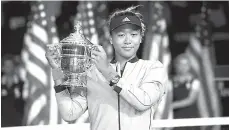  ?? — Gambar AFP ?? BERSEJARAH: Osaka menjulang trofi Terbuka AS yang dimenangi selepas menewaskan Serena pada aksi final di New York City.