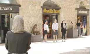  ?? (Marc Israel Sellem/The Jerusalem Post) ?? ALL MOVEMENT freezes at Jerusalem’s Mamilla Mall yesterday, as shoppers stand at attention during the two-minute siren marking Holocaust Remembranc­e Day.