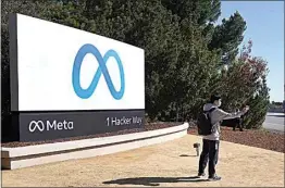  ?? TONY AVELAR / AP ?? A Facebook employee takes a selfie in front the company’s new name and logo outside its headquarte­rs in Menlo Park, Calif., on Thursday after Facebook Inc. announced that it is changing its name to Meta Platforms Inc.