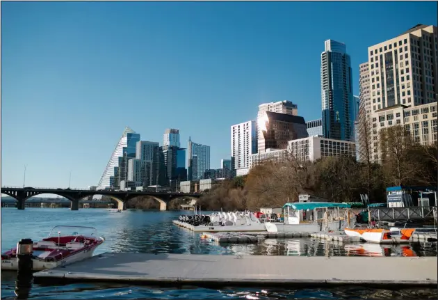  ?? PHOTOS BY STACY SODOLAK — THE NEW YORK TIMES ?? Lady Bird Lake in Austin, Texas, with the Congress Bridge rowing dock in the foreground on Feb. 18. It’s a good place to enjoy the scenery in a kayak, canoe or paddleboar­d.