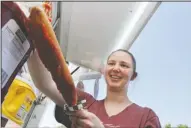  ?? File photo ?? Festival food: Lori Aaron squeezes condiments on her corndog while attending the last year’s South Arkansas Mayhaw Festival.