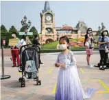  ?? HECTOR RETAMAL/AFP ?? ATURAN BARU: Pengunjung anak-anak mengenakan gaun dan masker saat antre memasuki Shanghai Disney Resort kemarin.