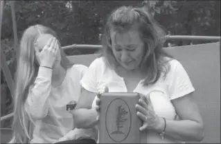  ?? FRANK GUNN, THE CANADIAN PRESS ?? Denise Lane and her daughter Megan sit with the urn containing the ashes of her son Shawn Kelly Jr.