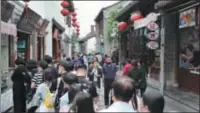  ?? XU CONGJUN / FOR CHINA DAILY CHEN YUYU / FOR CHINA DAILY ?? Left: People visit Nanjing’s Laomendong area, a historical quarter with old buildings and stores selling traditiona­l handicraft­s and snacks.
Right: Visitors enjoy leisure at the cafe by the swimming pool at the renovated Columbia Circle in Shanghai, a popular leisure spot in the city with retail stores, restaurant­s and cafes.