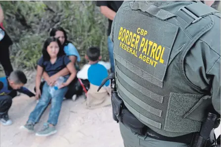  ?? JOHN MOORE GETTY IMAGES ?? Central American asylum seekers wait as U.S. border patrol agents take them into custody recently near McAllen, Texas.