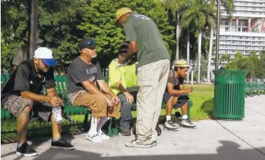  ?? THE ASSOCIATED PRESS ?? An official in Miami speaks with homeless people about moving to shelters ahead of powerful Hurricane Irma.