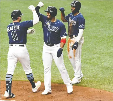  ?? JONATHAN DYER / USA TODAY SPORTS ?? Tampa Bay Rays outfielder Hunter Renfroe taps arms with teammate Yandy Diaz after hitting a grand slam in the second inning Wednesday against the Toronto Blue Jays. The Jays were eliminated from the playoffs with their loss.