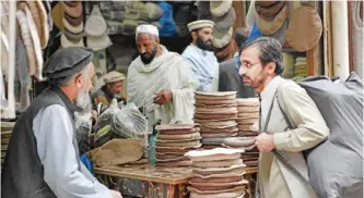  ??  ?? PESHAWAR: Pakistani customers buy traditiona­l Chitrali hats called ‘Pakol’, ahead of the winter season, at a market in Peshawar yesterday. A pakol is a traditiona­l Pashtun woollen hat which is a rolled, flat hat made from a mix of sheep’s wool and goat...