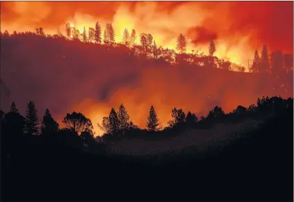  ?? THE ASSOCIATED PRESS ?? The Camp Fire burns along a ridgetop near Big Bend, Calif., on Saturday, Nov. 10, 2018. Crews working to contain the blaze overnight faced deteriorat­ing weather conditions according to Calfire as winds picked up and humidity dropped.