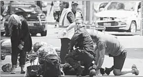  ??  ?? Ambulance officers attend to the injured when a car drove into a crowd in Melbourne.
(Photo: Getty Images)