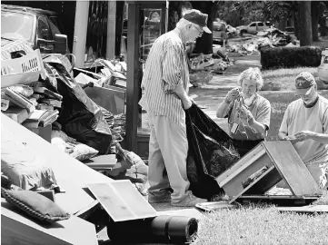  ??  ?? People sort through belongings found in y flood damage in Houston. — Reuters photo