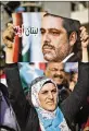  ?? BILAL HUSSEIN / AP ?? A woman holds up a picture of Lebanese Prime Minister Saad Hariri outside his residence in Beirut on Wednesday.
