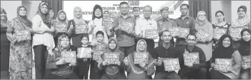  ??  ?? Fatimah (sixth left), Noriah (fifth left) and Amiruddin (centre) with participan­ts of the parenting workshop.