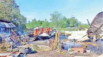  ??  ?? Fire and rescue personnel carrying out investigat­ion at the scene of the fire at Kampung Binsulok in Membakut.