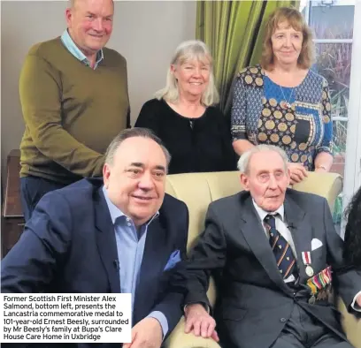  ??  ?? Former Scottish First Minister Alex Salmond, bottom left, presents the Lancastria commemorat­ive medal to 101-year-old Ernest Beesly, surrounded by Mr Beesly’s family at Bupa’s Clare House Care Home in Uxbridge